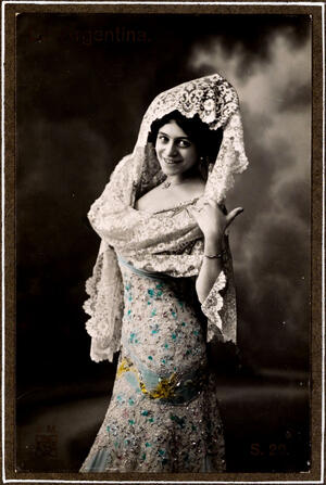 Con vestido de encajes y lentejuela, y mantilla blanca de blonda